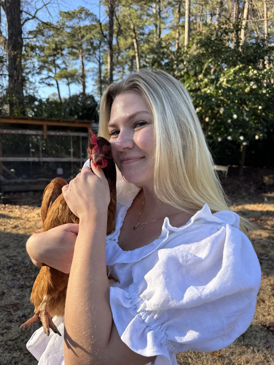 Molly in her backyard holding one of her chickens