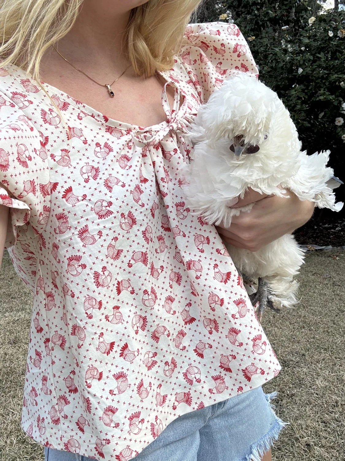 Molly in a floral blouse holding Ziggy